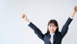 白背景で万歳をする笑顔の若い女性（前髪あり）