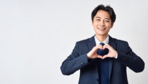 白背景でハートマークを作る男性（ストライプスーツ）