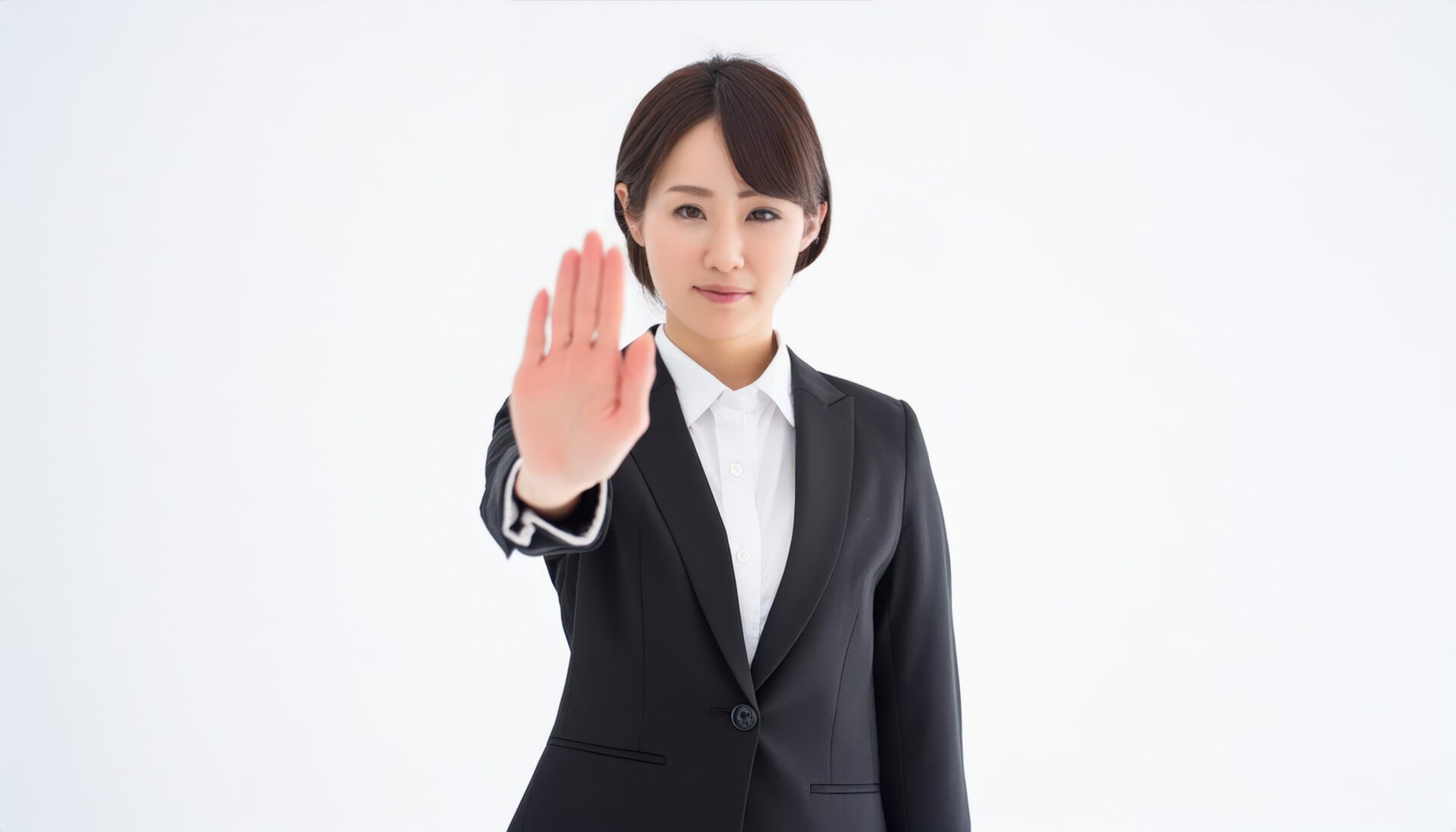 白背景でストップサインをする若い女性