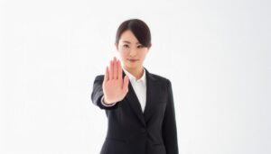 白背景で手のひらを前にかざす若い女性