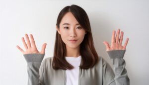 白背景で両手を上げる若い女性