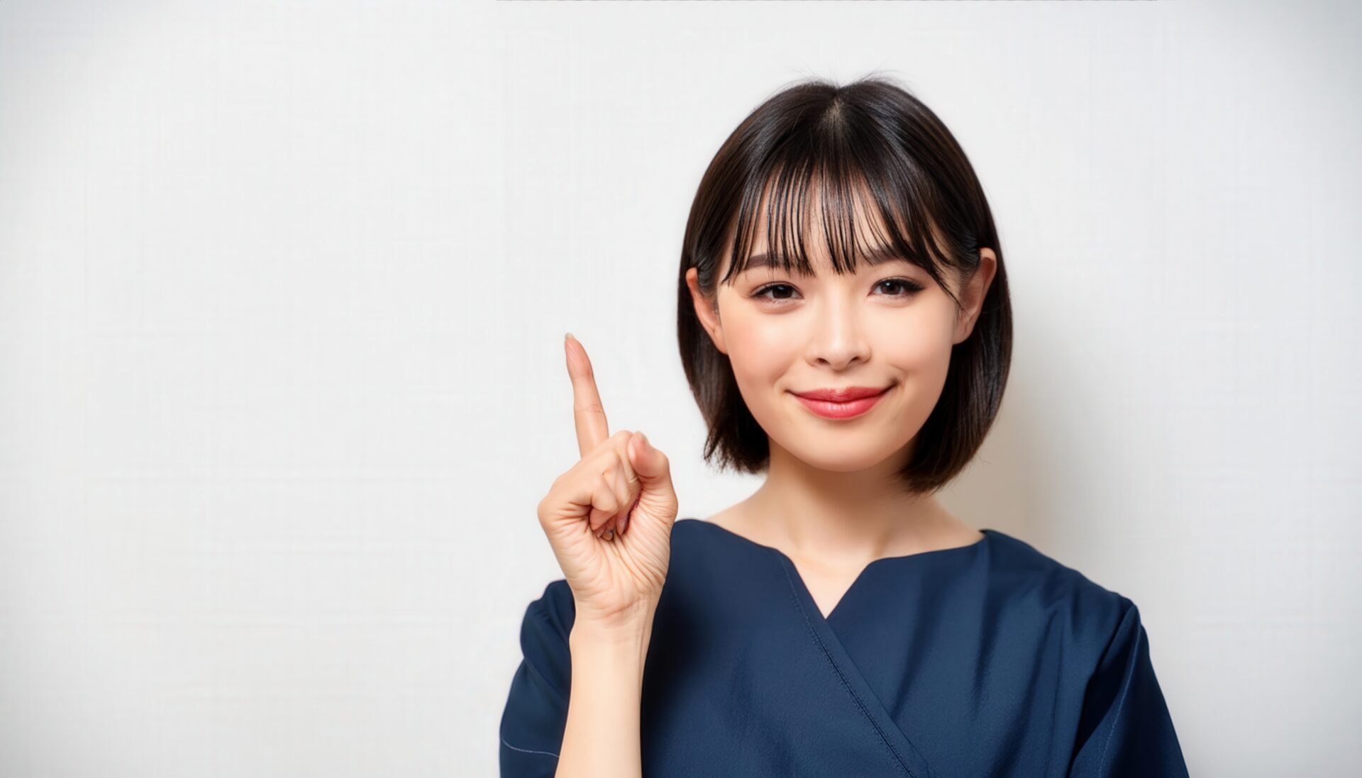 白背景で人差し指を立てる若い女性（ネイビー制服）