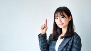白背景で人差し指を立てる若い女性（ストライプジャケット）