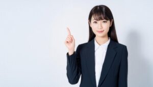 白背景で人差し指を立てる笑顔の若い女性