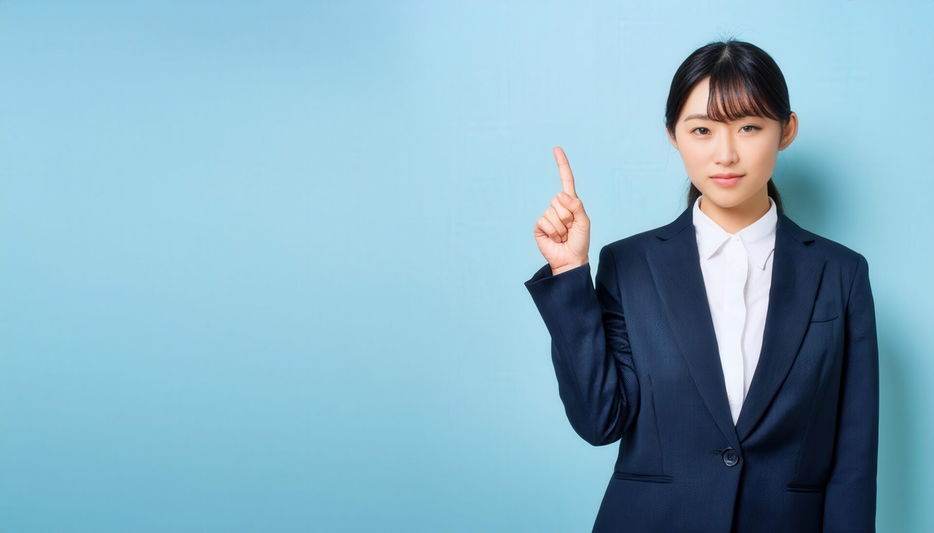 淡い青色背景で指をさす笑顔の若い女性