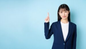 水色背景で指をさす笑顔の若い女性