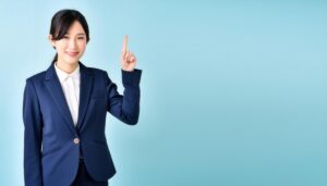 水色背景で人差し指を立てる笑顔の若い女性