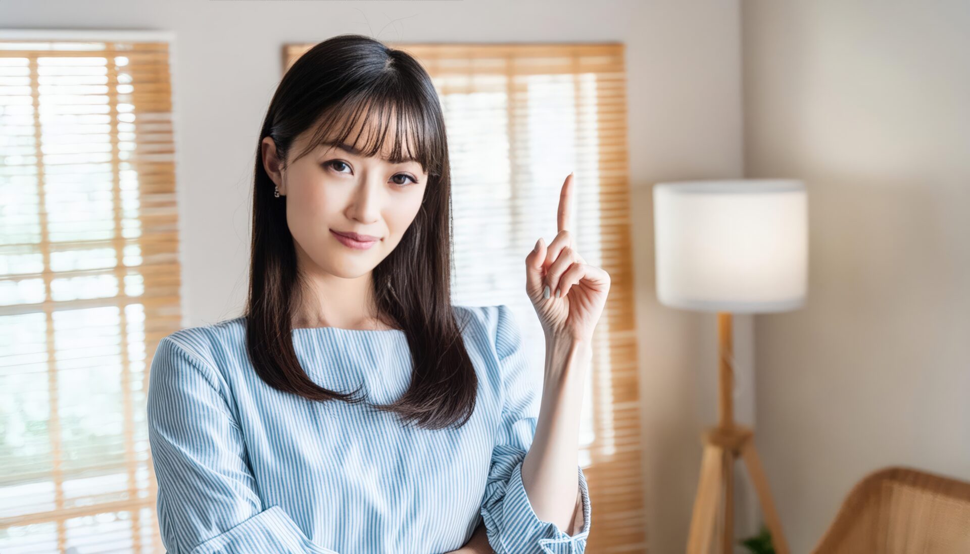 室内で人差し指を立てる笑顔の若い女性