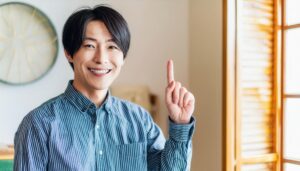 ストライプシャツを着た若い人が指をさす