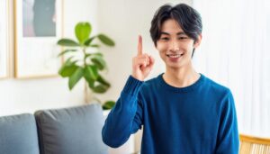 青いセーターを着た若い人が指をさす