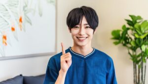 ブルーのトップスを着た若い人が指をさす