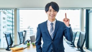 会議室でスーツ姿の若い人が指をさす