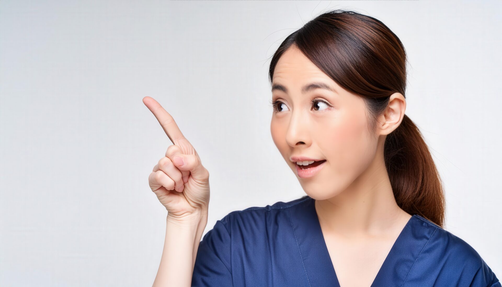 白背景で医療用ユニフォームを着た若い人が指をさす