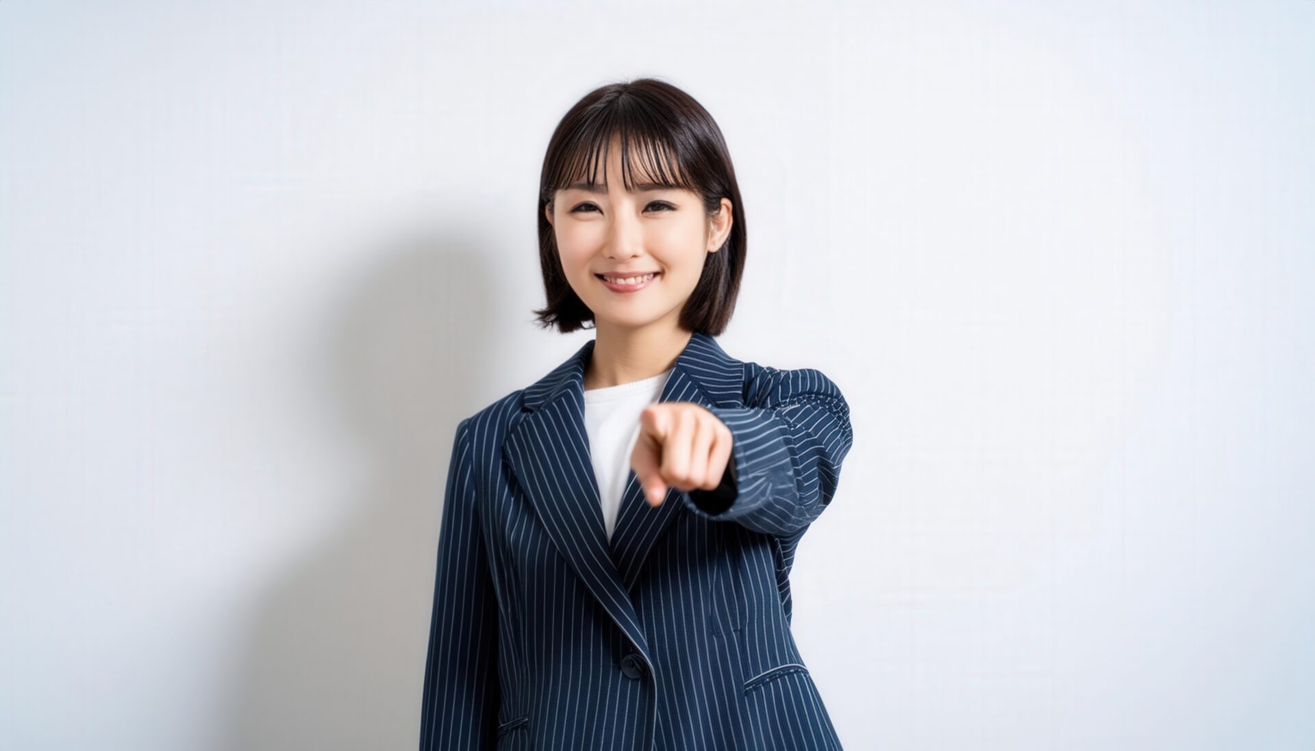 ストライプスーツを着た若い人が指をさす