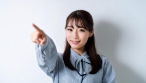ストライプのリボンブラウスを着た若い人が指をさす