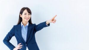 ストライプシャツを着たスーツ姿の若い人が指をさす