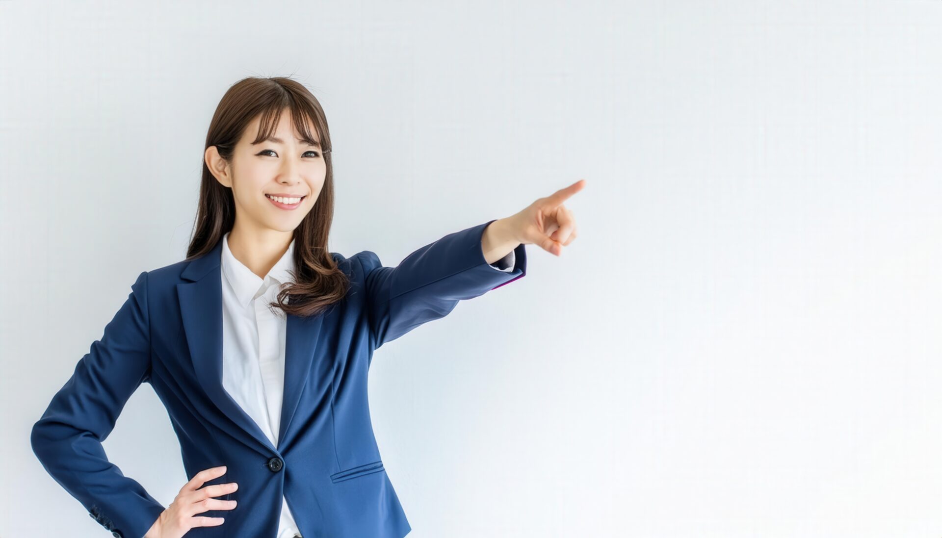 スーツ姿の若い人が指をさす