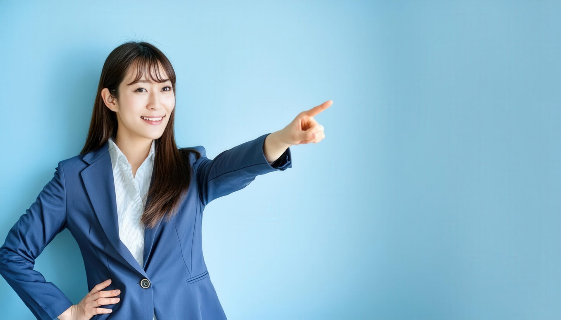 水色の背景でスーツ姿の若い人が指をさす