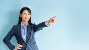 水色の背景でスーツ姿の若い人が指をさす