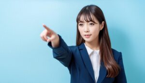 水色背景でスーツ姿の若い人が指をさす
