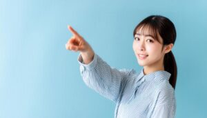水色背景でストライプシャツを着た若い人が指をさす