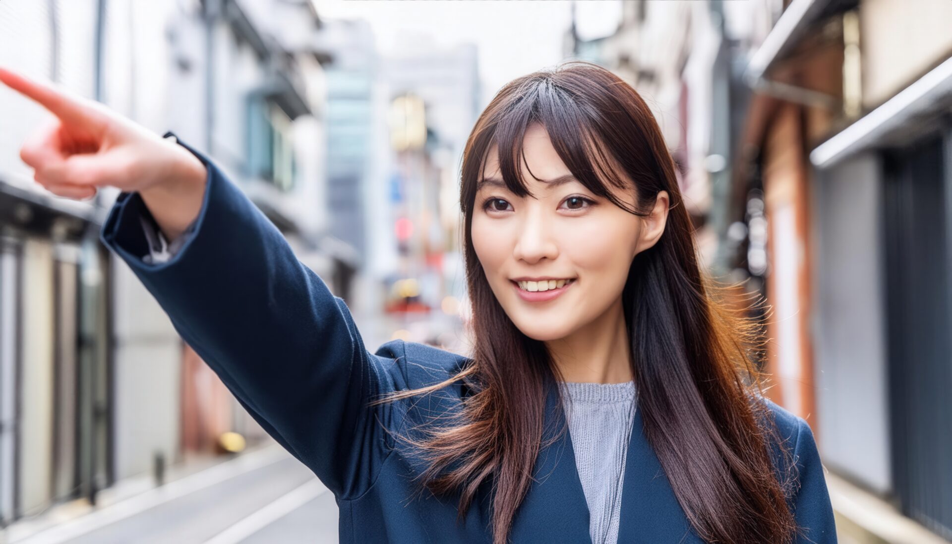 街中でネイビーのアウターを着た若い人が指をさす