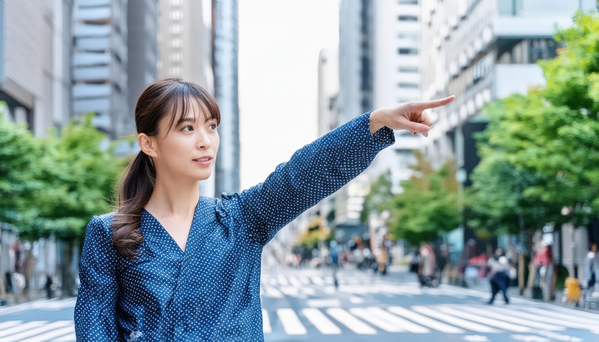 街中でドット柄のトップスを着た若い人が指をさす