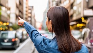 後ろ姿のデニムシャツを着た若い人が街中で指をさす