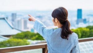 ストライプのトップスを着た後ろ姿の若い人が街を指す