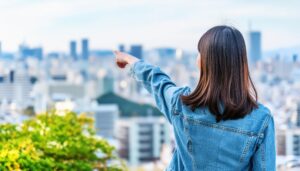 デニムジャケットを着た後ろ姿の若い人が街を指す