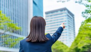 後ろ姿のスーツ姿の人が建物を指す