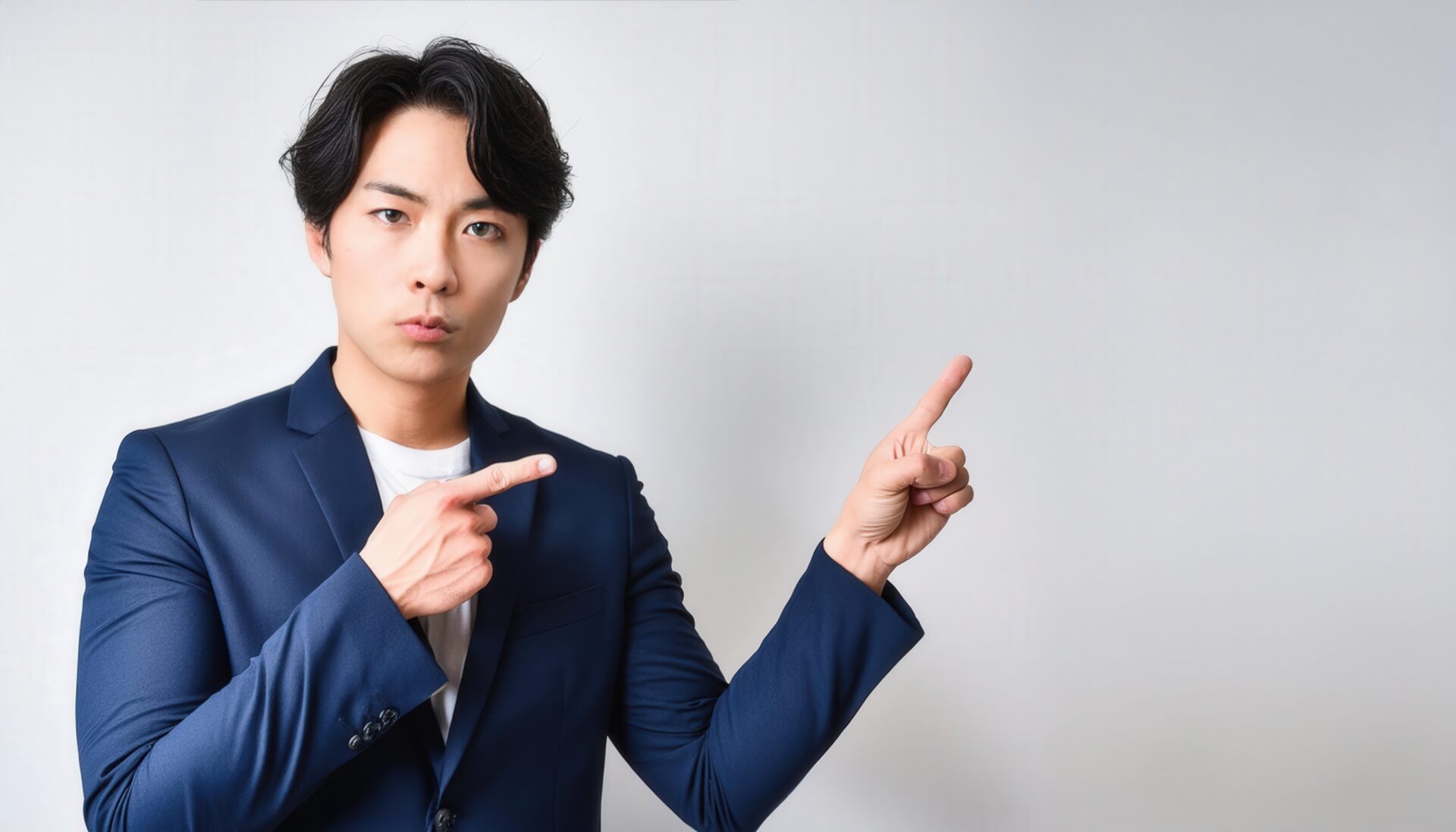 スーツ姿の人が両手で指をさす