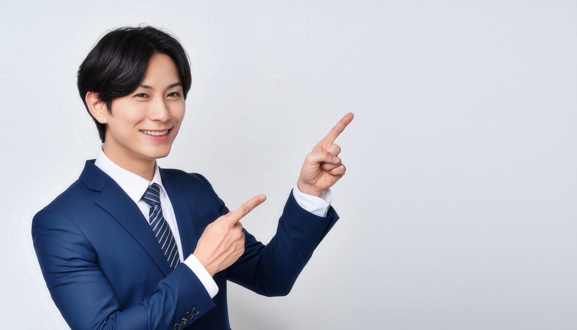 白背景でネイビーのスーツを着た若い男性が両手で指さす