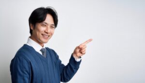 白背景でセーターを着た若い男性が右を指さす