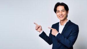 白背景でネイビーのスーツを着た若い男性が左右を指さす