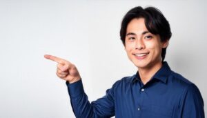 白背景でネイビーのシャツを着た若い男性が左を指さす