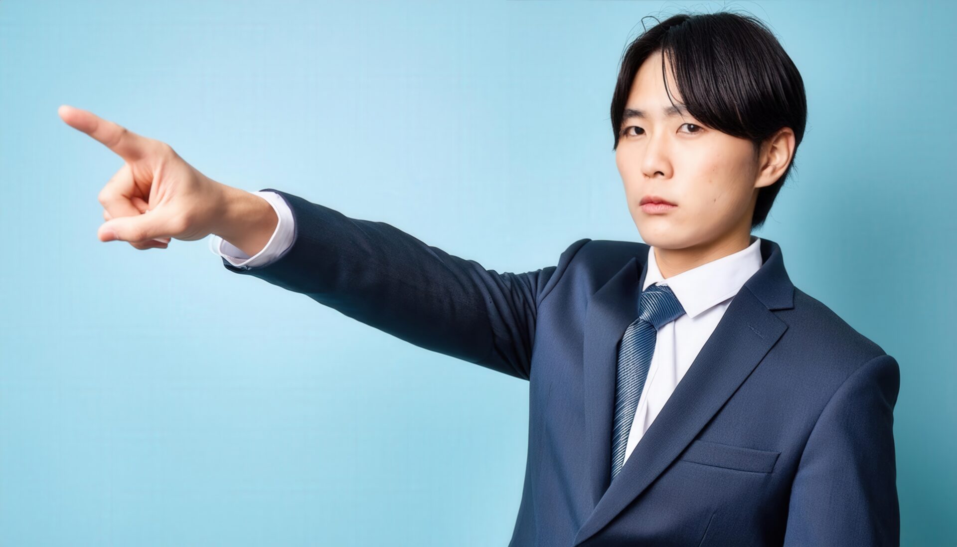 青背景でネイビースーツを着た若い人が前方を指さす
