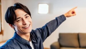 フォーマルなシャツを着た若い男性が斜め前を指さす