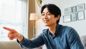 室内でストライプシャツを着た若い男性が右を指さす