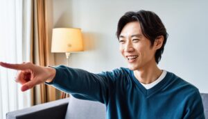 室内でブルーのセーターを着た若い男性が左を指さす