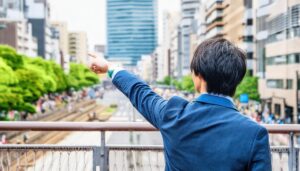 街を見渡しながら指をさす後ろ姿の若い男性