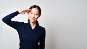 ネイビーのニットで敬礼ポーズをする若い女性