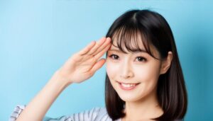 ストライプトップで敬礼ポーズをする若い女性(青背景)