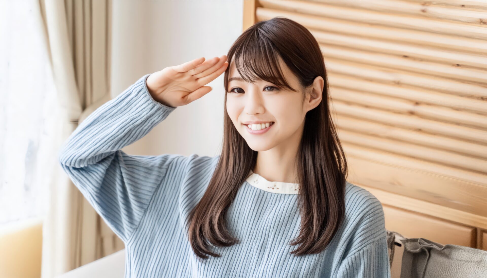 室内で水色のセーターを着て敬礼する人物