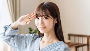 室内で水色のトップスを着て敬礼する人物