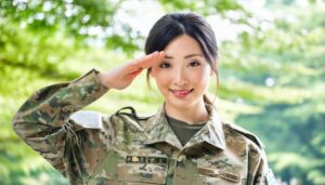 屋外で迷彩柄の軍服を着て敬礼する人物
