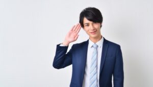 白背景でネイビーのスーツを着て敬礼する人物