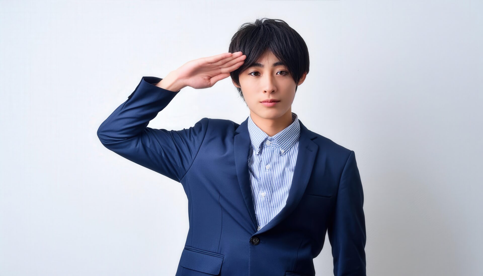 白背景でストライプシャツと青いスーツを着て敬礼する人物