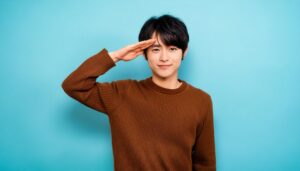 青背景でブラウンのニットを着て敬礼する人物