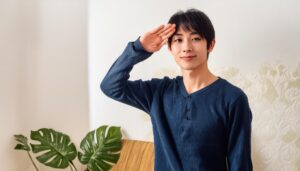 リビングで敬礼する男性